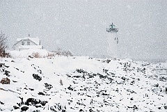 Portsmouth Harbor Lighthouse Over Rocky Coast in Snowstorm